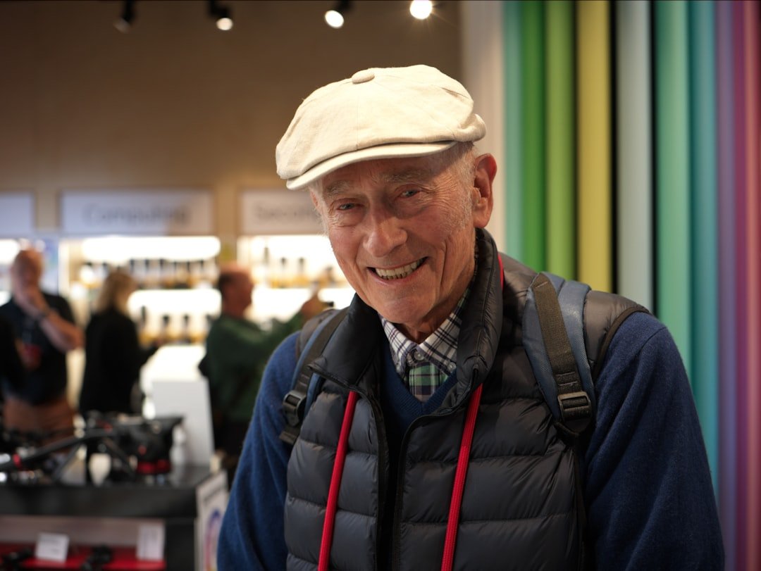 Grandpa in hat & vest, sharing wisdom.
