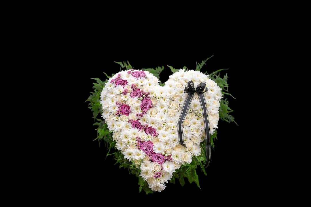Heart-shaped floral memorial, white purple flowers, keepsake tribute.