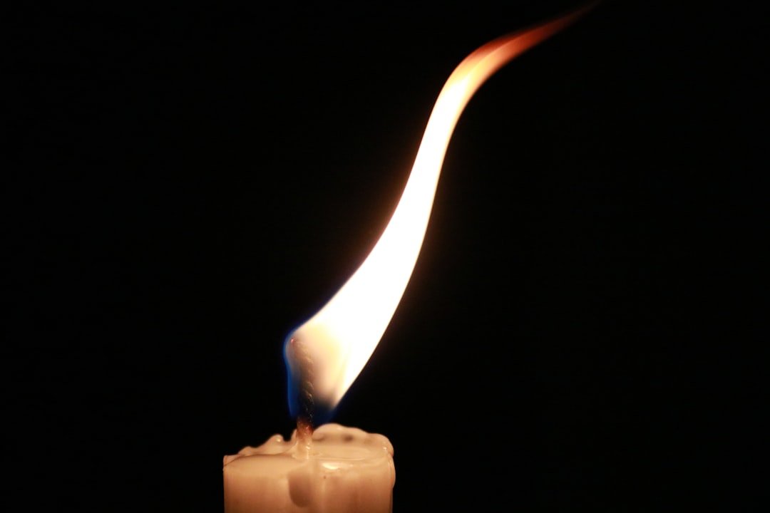 White candle, black background, trauma-informed goodbye writing.