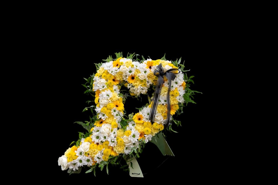 Heart-shaped floral arrangement: white and yellow daisy tribute.