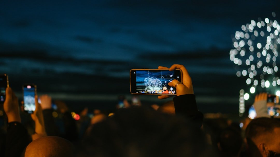 Crowd recording farewell tribute on cell phones.