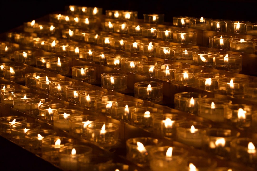 Lit candles dimly glow in a dark room.