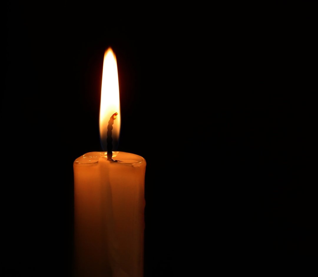 Lit candle, digital memorial tribute SEO alt text.