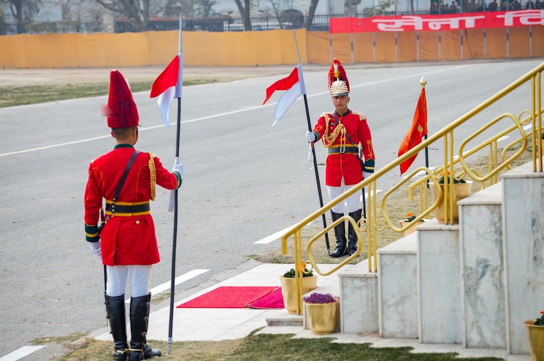Red-uniformed guards honor fallen first responder hero with flags.